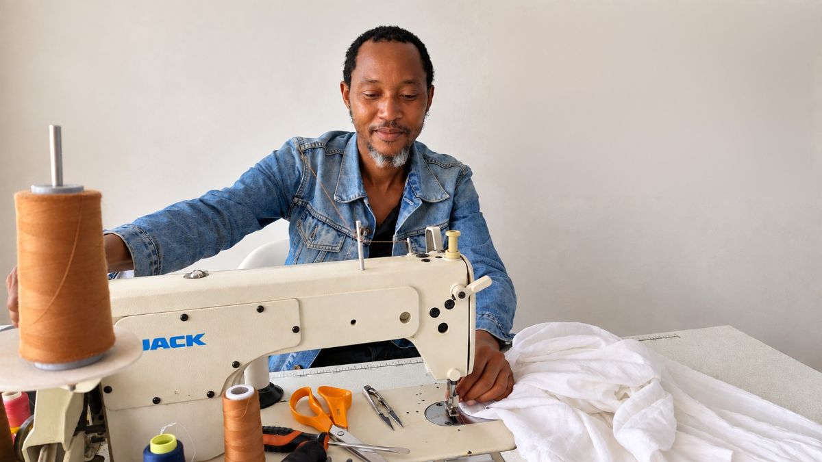 Ephraim smiling at his sewing machine